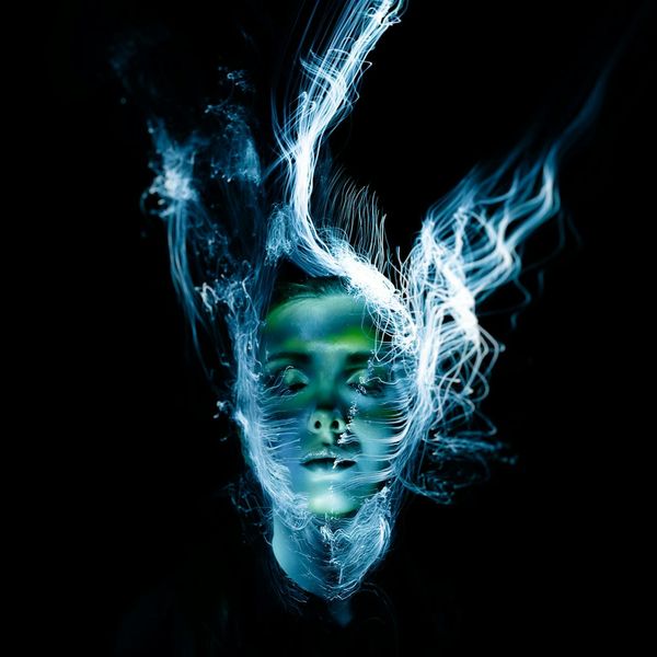 Person doing a dynamic yoga stretch, silhouette with light glowing.